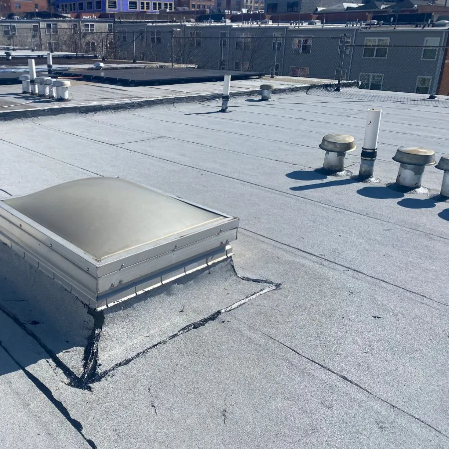 Flat roof with skylight and rooftop vents in urban area