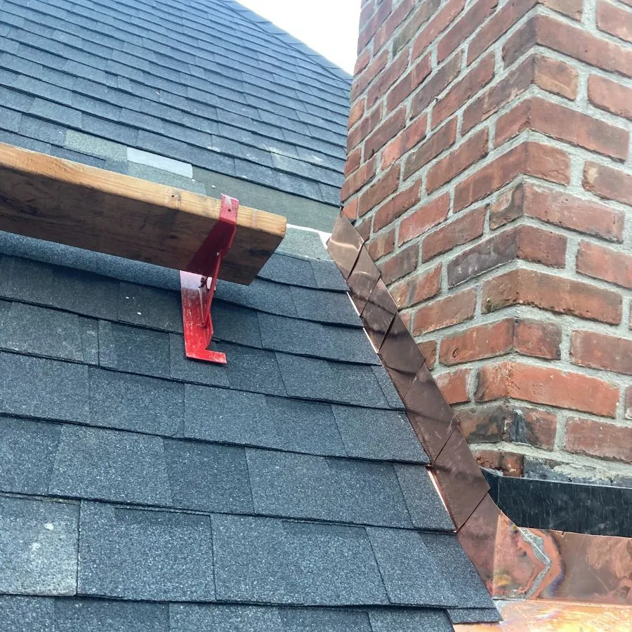 Chimney flashing installation on asphalt shingle roof