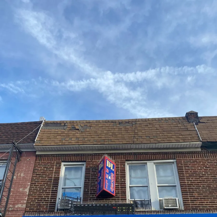 Damaged shingle roof above storefront