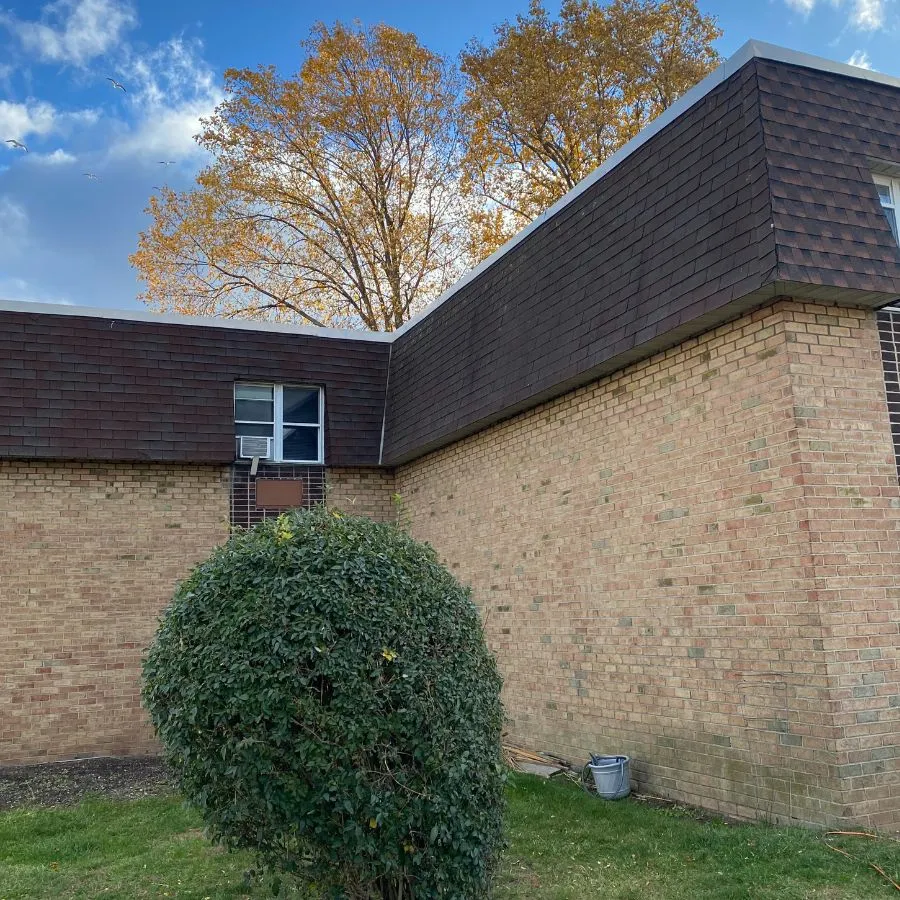 Exterior view of flat roof building with brown shingles