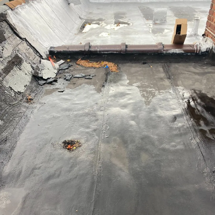 Flat roof damage with water pooling and debris