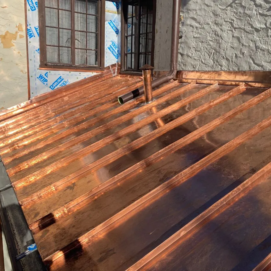 New copper metal roof installation near windows